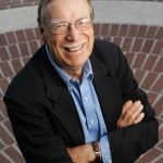Portrait of R; Earterlin, smiling, seen from above on a brick pavement